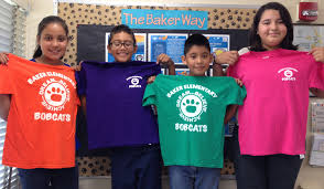 Picture of Baker Elementary students holding up Baker Bobcats t-shirts in variety of colors.