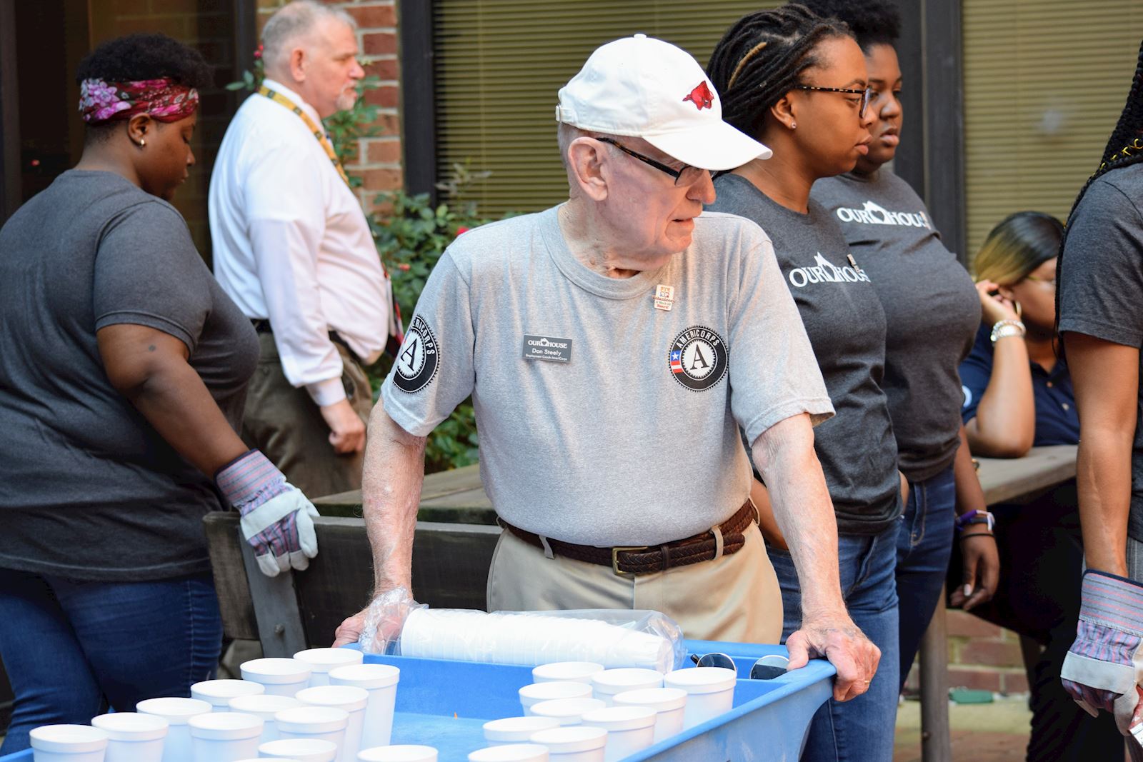 A Senior AmeriCorps member moves a bin with cups to serve the homeless